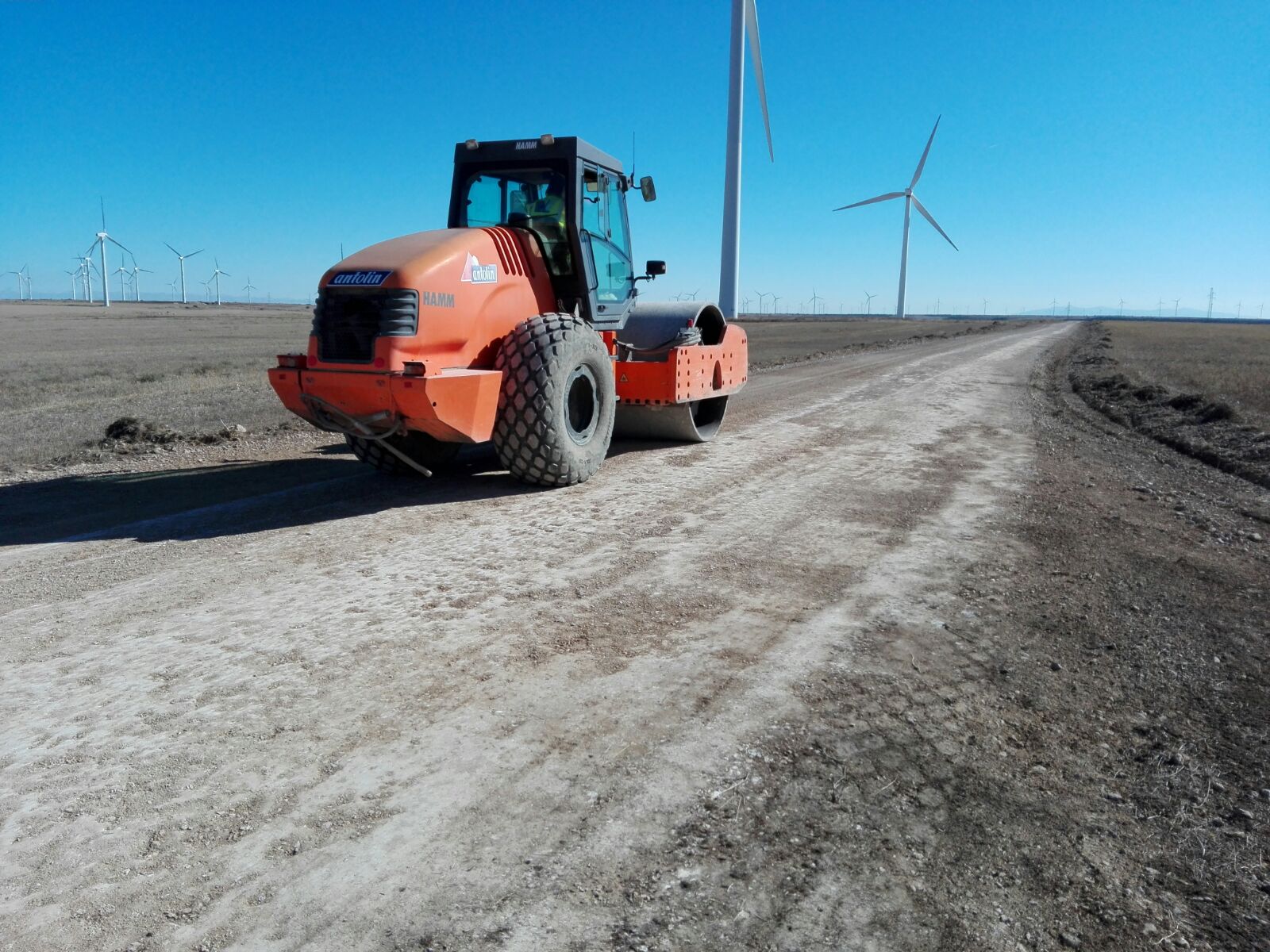 Rodillo compactador trabajando sobre un vial de parque eólico